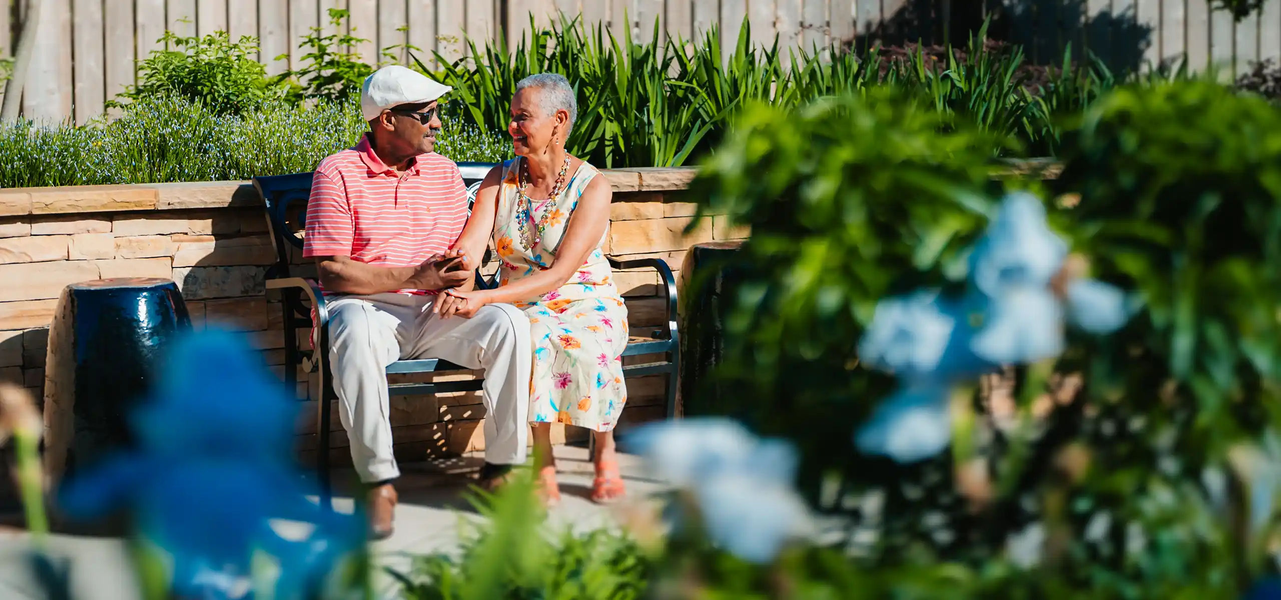 Retired couple sitting on a bench outside