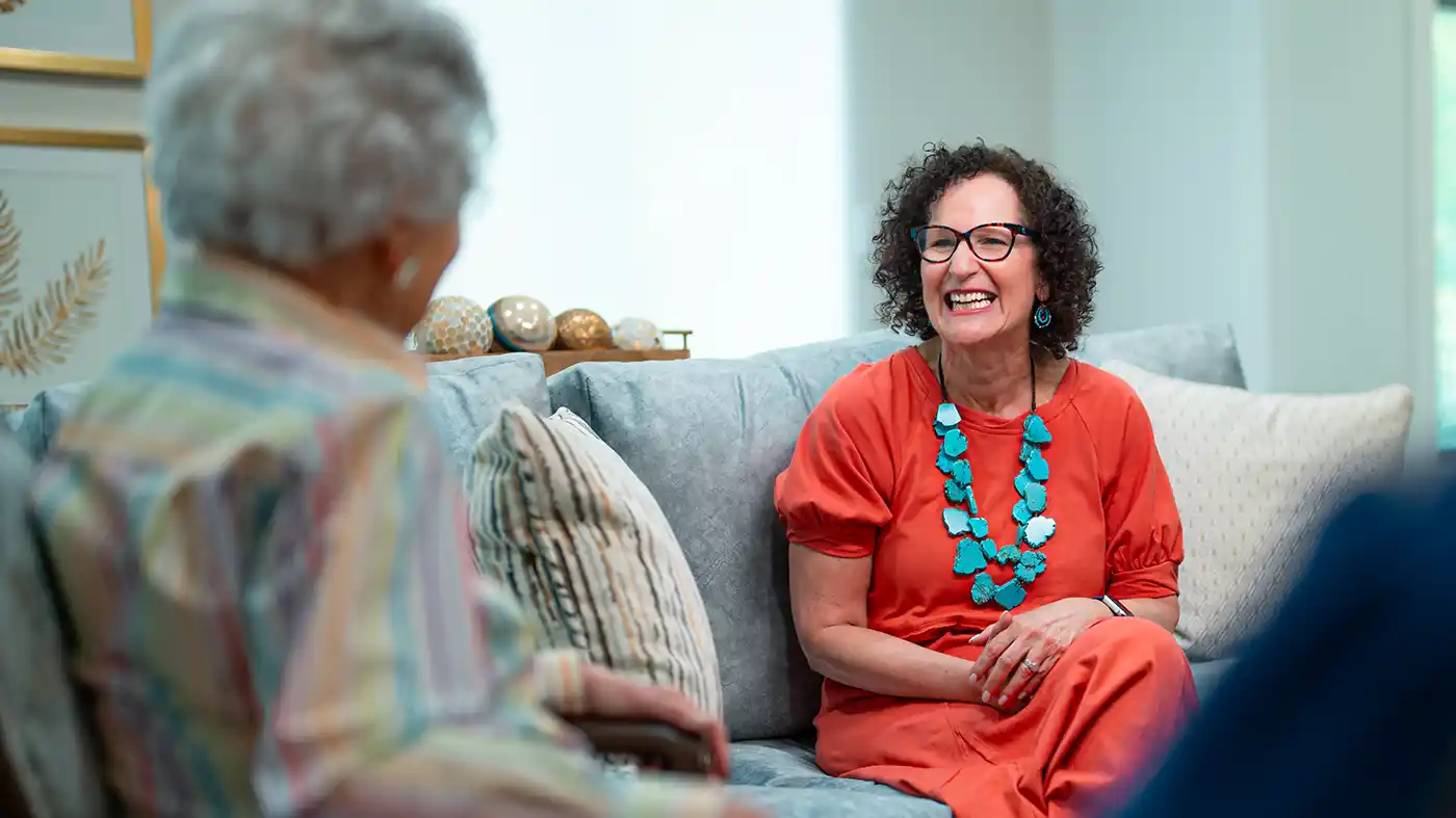 Retired woman sitting on a couch having a conversation